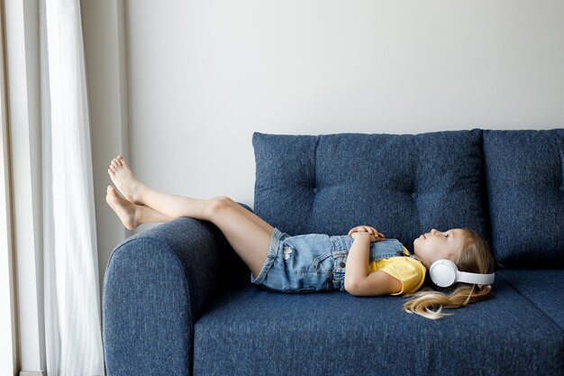 jolie petite fille au casque se détendre à la maison