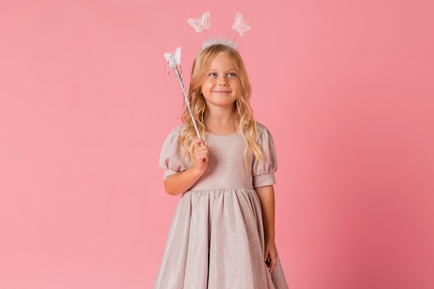 Jolie petite fille avec baguette en costume