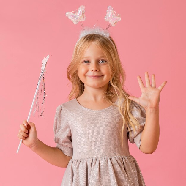 Jolie petite fille avec baguette en costume