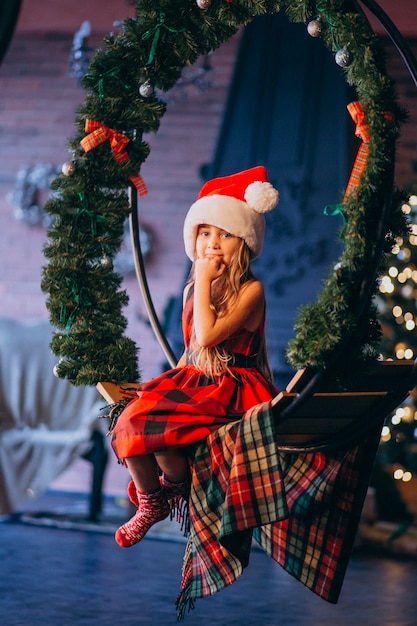 Jolie petite fille en bonnet de noel et robe rouge