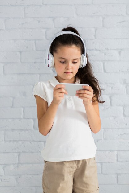 Jolie petite fille écoutant de la musique avec des écouteurs