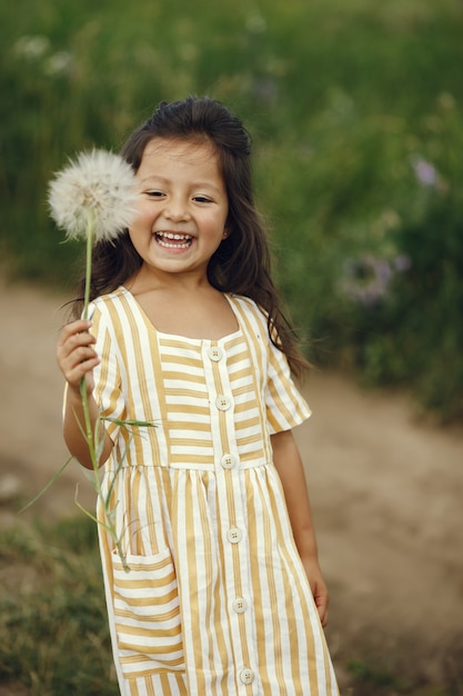 Photo gratuite jolie petite fille jouant dans un champ d'été