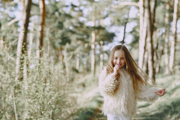 Jolie petite fille jouant dans une forêt d'été