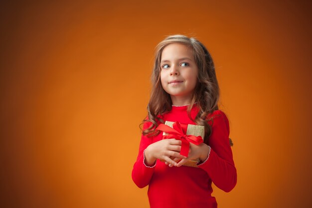 La jolie petite fille joyeuse sur fond orange