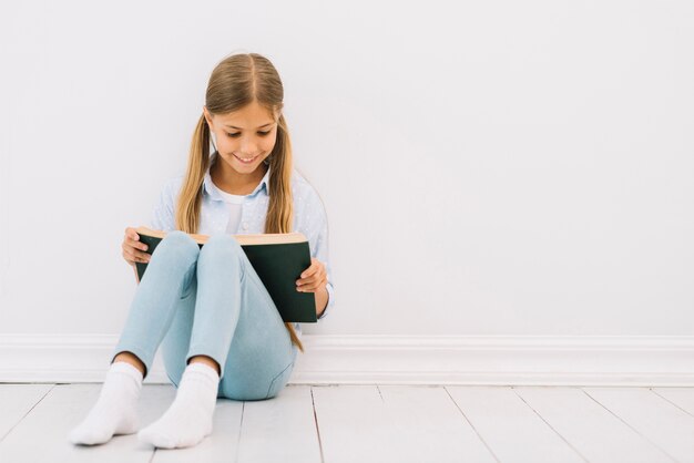 Jolie petite fille lisant un livre