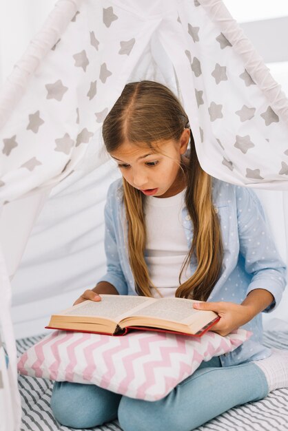 Jolie petite fille lisant un livre