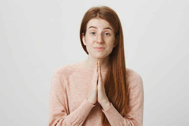 Jolie rousse demandant faveur, plaidant ou disant désolé