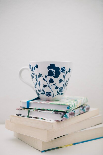 Jolie tasse sur une pile de livres