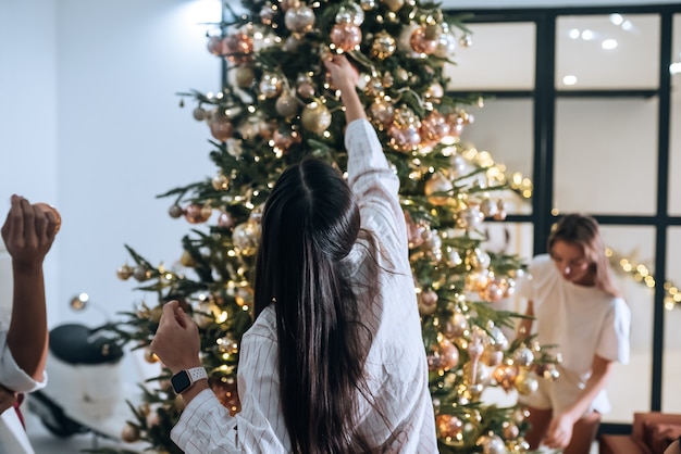 De jolies femmes attrayantes décore le sapin de Noël avec des boules