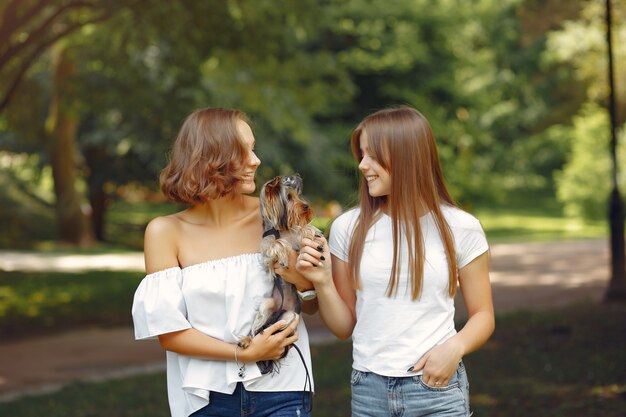 jolies filles dans un parc jouant avec petit chien