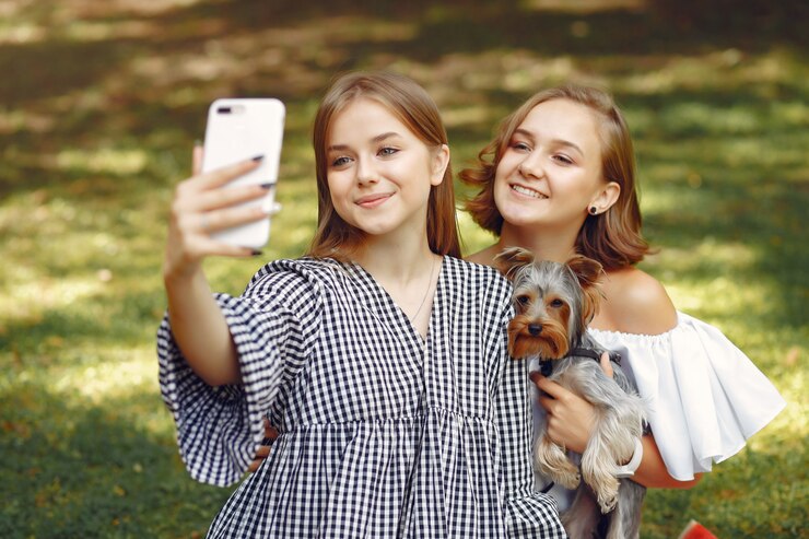 Photo gratuit jolies filles dans un parc jouant avec petit chien