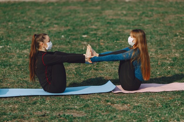 Jolies filles faisant du yoga dans un masque