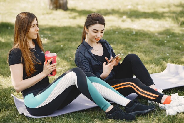 Jolies filles faisant du yoga dans un parc d'été