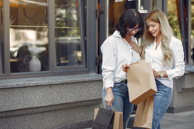 Jolies filles avec sac à provisions dans une ville