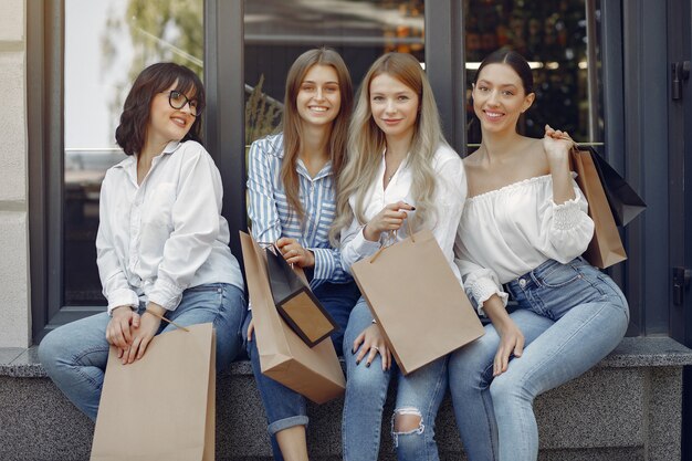 Jolies filles avec sac à provisions dans une ville