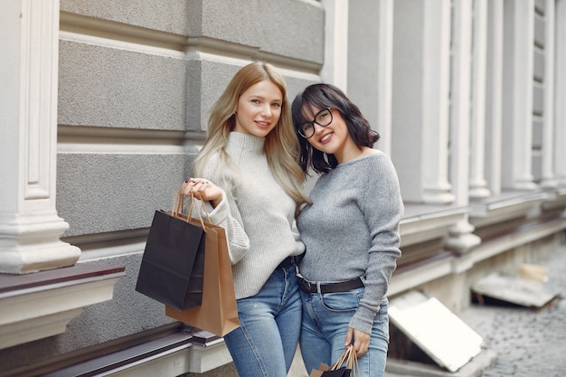 Jolies filles avec sac à provisions dans une ville