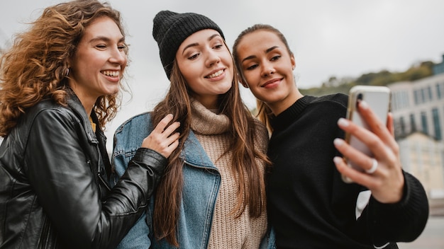 Jolies jeunes filles prenant un selfie ensemble