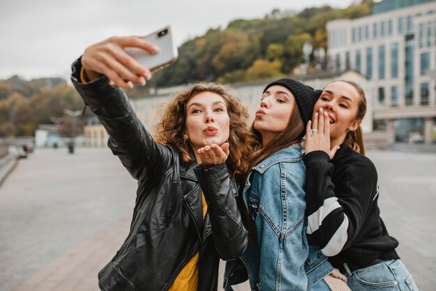 Jolies jeunes filles prenant un selfie ensemble