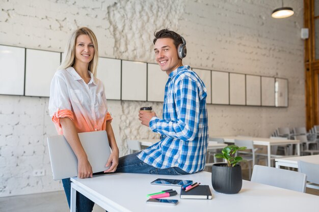 Jolies jeunes gens heureux élégants dans un bureau de co-working,