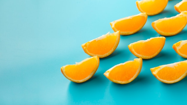 Photo gratuite jolies tranches d'orange à surface bleue