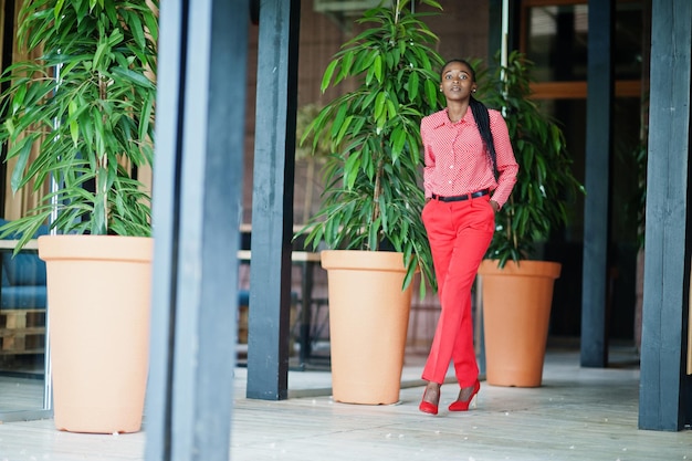 Photo gratuite jolies tresses affaires femme afro-américaine brillante personne autoritaire amicale porter bureau chemise rouge et pantalon