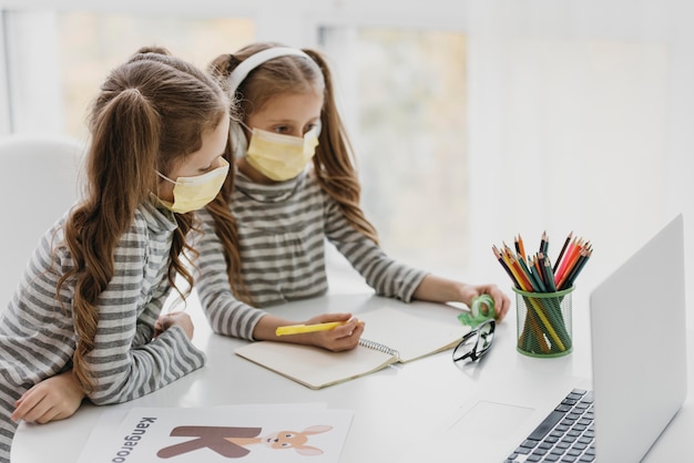 Jolis jumeaux portant des masques médicaux à l'intérieur