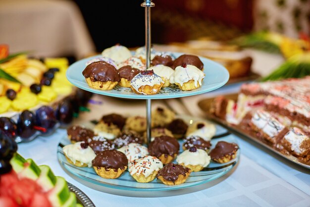 De jolis petits cupcakes blancs et bruns se dressent sur le plat fatigué