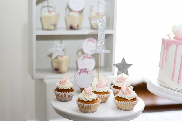 Jolis petits cupcakes à la crème blanche servis sur un plat blanc