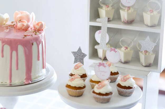 Jolis petits cupcakes à la crème blanche servis sur un plat blanc