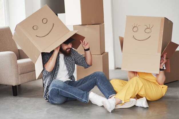 Jouer avec des boîtes. Heureux couple ensemble dans leur nouvelle maison. Conception du déménagement