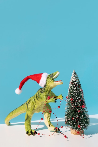 Jouet dinosaure près de sapin de Noël décoré