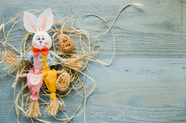 Jouet lapin près des oeufs sur le foin