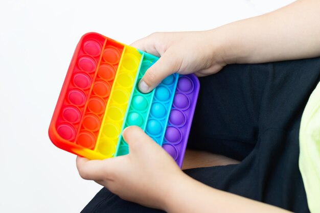 Jouet Sensoriel Anti-stress En Silicone Coloré Pop-it Dans Les Mains De L'enfant Jeu à La Mode Pour Enfants Et Adultes Photo Premium