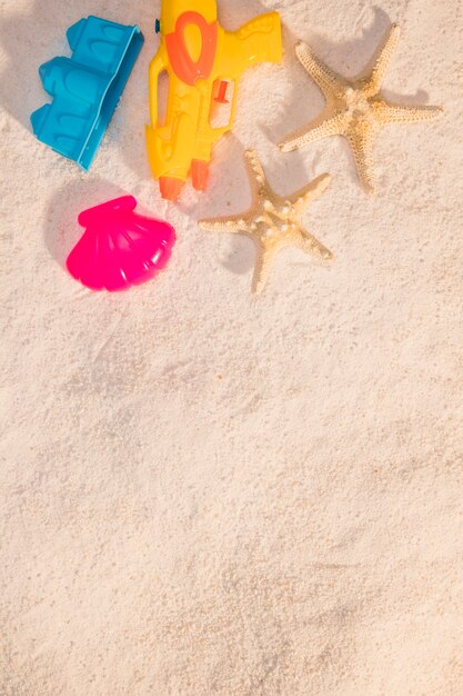 Jouets de plage et étoile de mer sur le sable