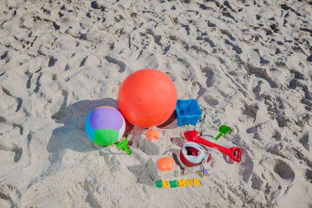 Jouets pour enfants sur le sable au soleil brillant