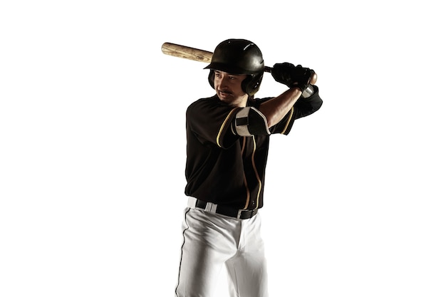 Joueur de baseball, lanceur dans un uniforme noir pratiquant et entraînement isolé sur un mur blanc. Jeune sportif professionnel en action et en mouvement. Mode de vie sain, sport, concept de mouvement.