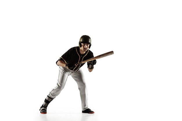 Joueur de baseball, lanceur dans un uniforme noir pratiquant et entraînement isolé sur un mur blanc. Jeune sportif professionnel en action et en mouvement. Mode de vie sain, sport, concept de mouvement.