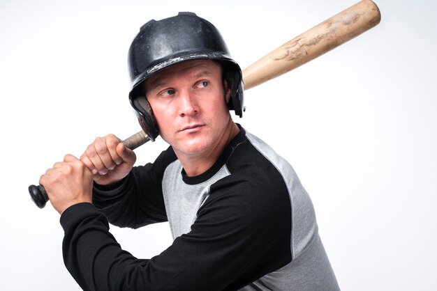 Joueur de baseball posant avec une batte et un casque