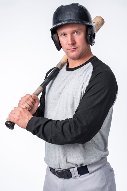 Joueur de baseball posant avec casque et batte