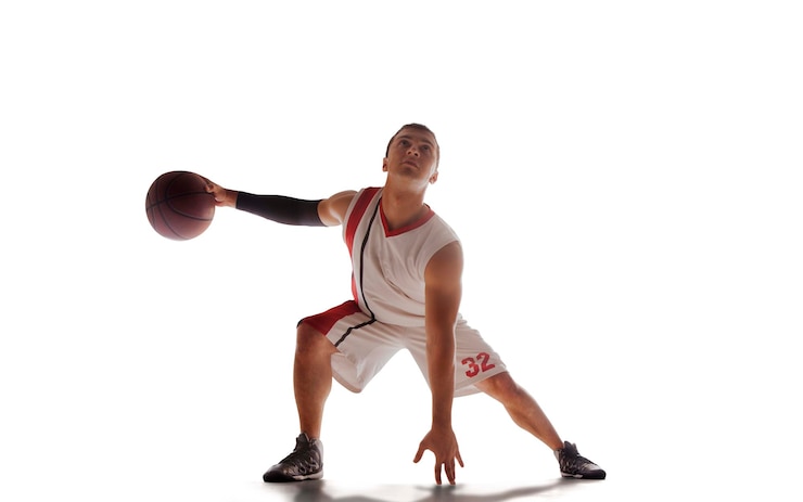 Photo gratuit un joueur de basket-ball en action au coucher du soleil