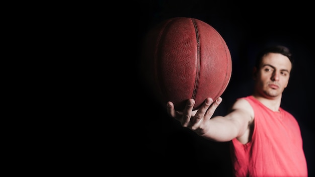 Photo gratuite joueur de basket-ball posant avec le ballon