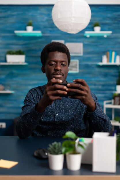 Joueur étudiant tenant le téléphone en position horizontale