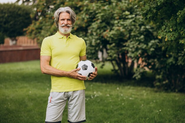 Joueur de football d'âge moyen avec ballon de football