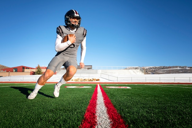 Photo gratuite joueur de football américain masculin en uniforme sur le terrain