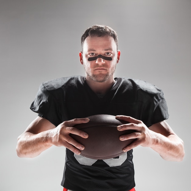 Photo gratuite joueur de football américain posant avec ballon