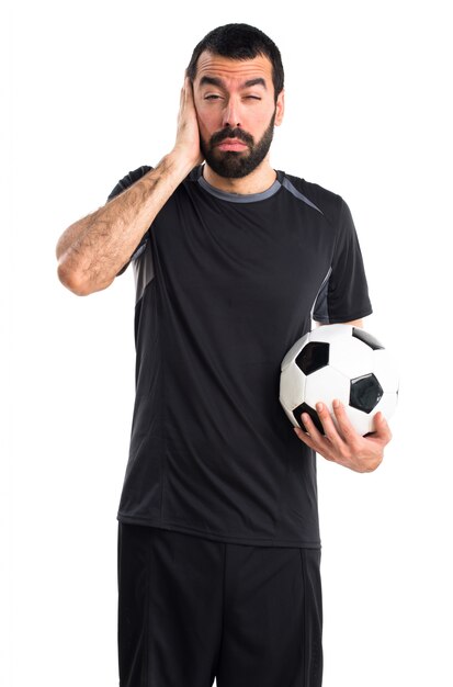 Joueur de football couvrant ses oreilles