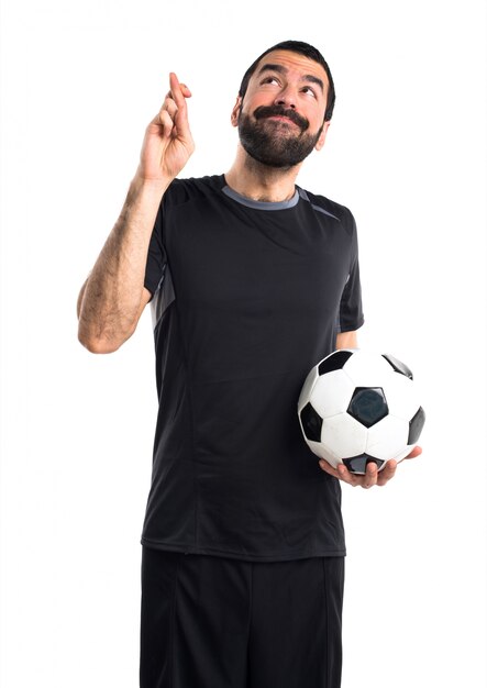 Joueur de football avec les doigts croisés