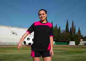 Photo gratuite joueur de football femme coup moyen sur le terrain