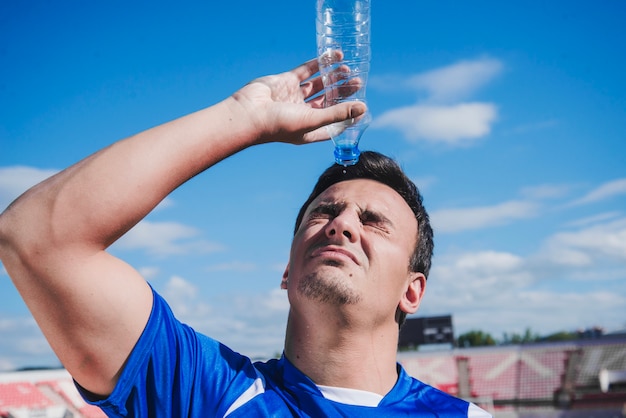 Joueur de football rafraîchissant avec de l&#39;eau