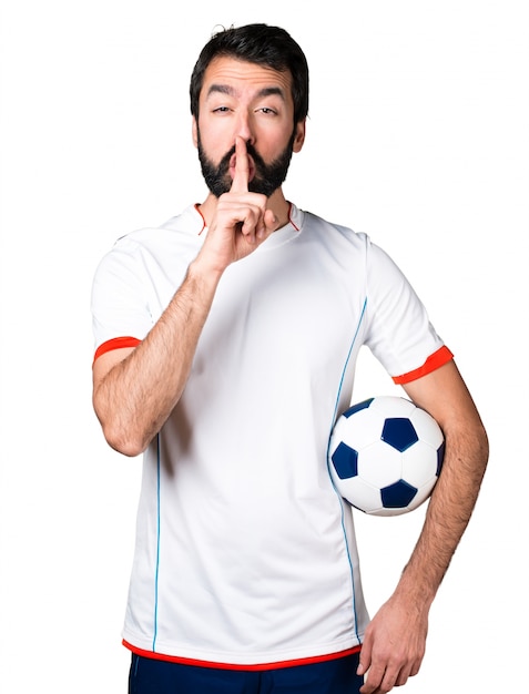 Photo gratuite joueur de football tenant un ballon de football faisant un geste de silence